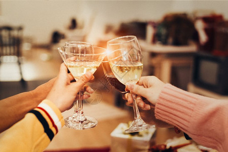 人们节日快乐的庆祝新年晚会人手在家里喝着酒杯介绍背景新年和圣诞派对的概念幸福与友谊有趣的是一串连在起的闪亮玻璃新一年和圣诞派对的图片