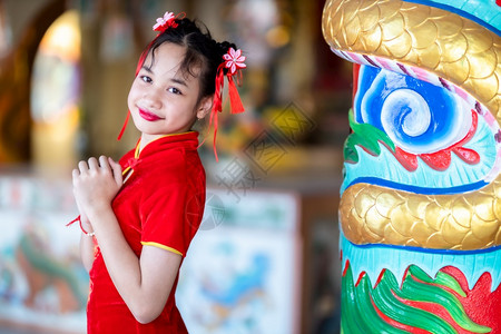 裙子宗教身着中华新年节国青春红传统香藏装饰的可爱亚洲小女孩长得一脸美丽的笑并戴着彩礼乐趣图片