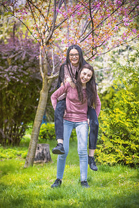 现代的黄色两个漂亮姐妹女孩拥抱玩得开心在一起穿着潮时装积极情感有两个姐妹在公园里玩得开心情绪图片