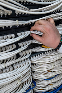 在职的白色男子在网络服务器室工作拥有数字通信和互联网络开关光纤枢纽的网络服务器机房金属丝图片