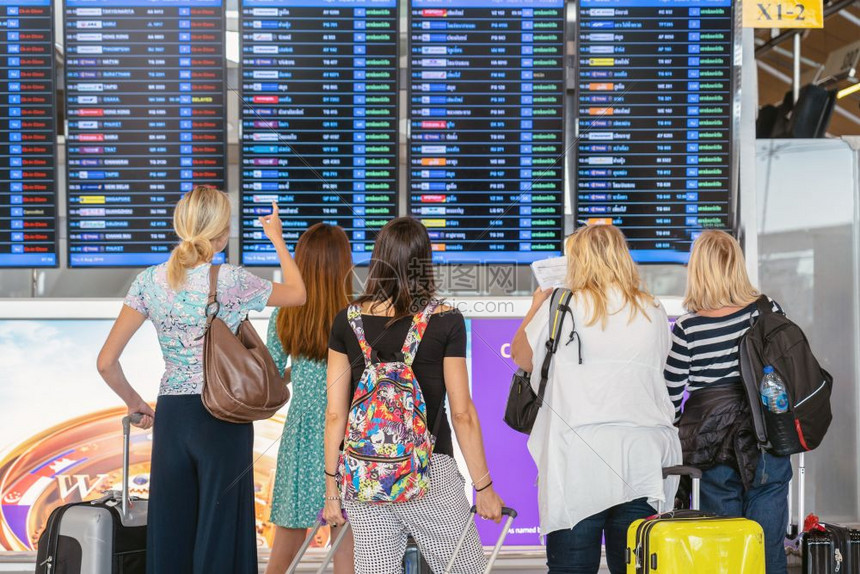 现代的木板在机场的飞行信息屏幕旅和带有技术概念的运输上登入飞行信息屏在机板上站着行李的旅客背靠边办理登机记手续提箱图片