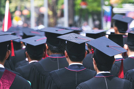 流苏大学毕业生持帽子的毕业生和成功者教育概念在高等教育中保持知识背景图片