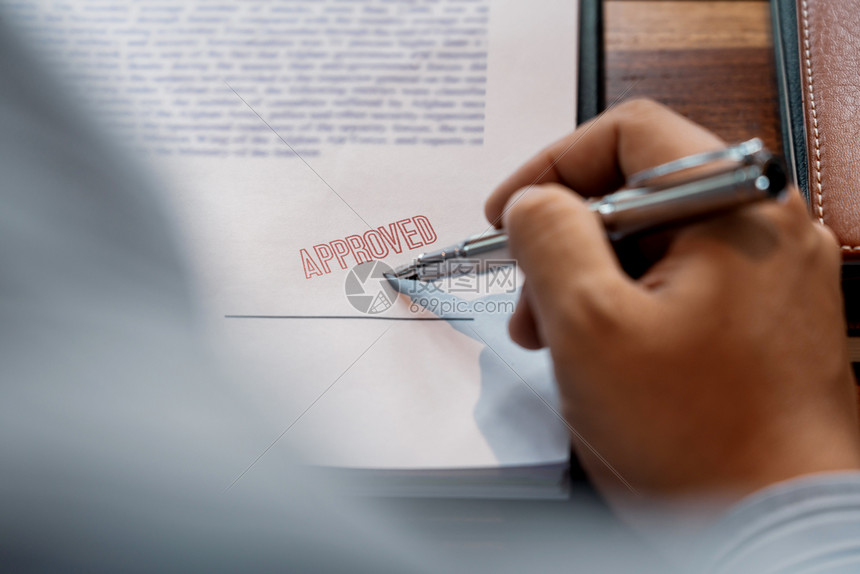 在核准贷款文件协议律师亲手概念的印章后男子在证书合同中签字或男高级商人在批准贷款文件协议书上加盖印章后文档或者工作图片