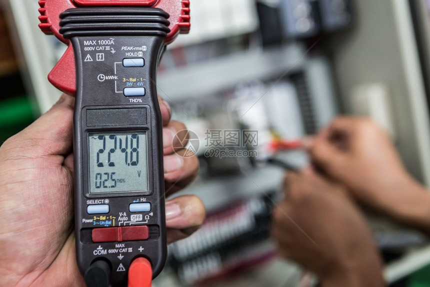 金属丝安全电气工程师正在用一个多米的仪表检查电气设备行业图片