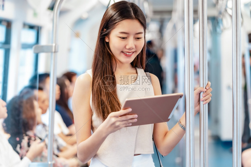 日本人青少年轻的乘坐地铁火车技术平板机的亚洲青年女乘客在大城市japanesechinese朝韩生活方式和日常commuter及图片
