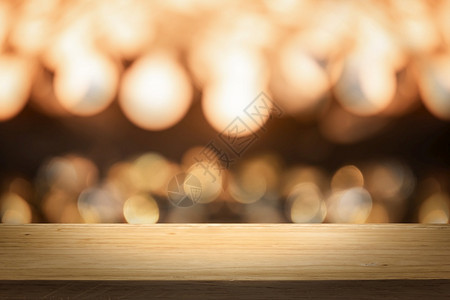 夜晚灯前木制桌背景的金色亮光灯bokeh抽象模糊空间用于产品目的现代图片