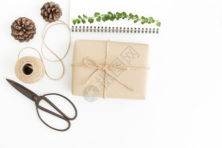锥体裹白色背景的顶端礼品箱和附件白地板上的手工礼品包装袋弓图片