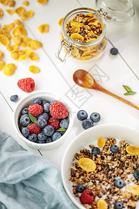蓝莓最佳营养有选择焦点白色木制桌上配有谷物和浆果的浅健康早餐图片