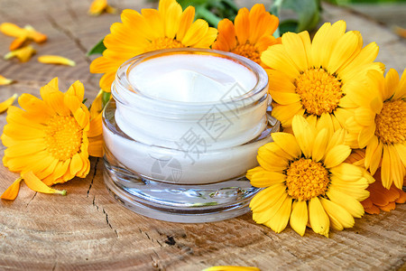 自然美丽软膏一罐用于身体护理的白色美容霜木质背景上的新鲜橙色金盏花医学皮肤科一罐用于身体护理的白色美容霜图片