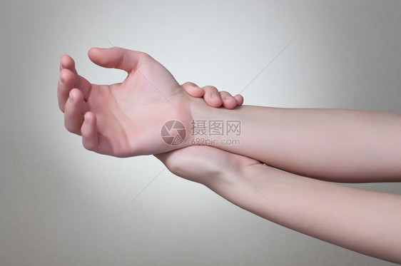 手臂前一种位年轻女触摸着她痛苦的手腕图片