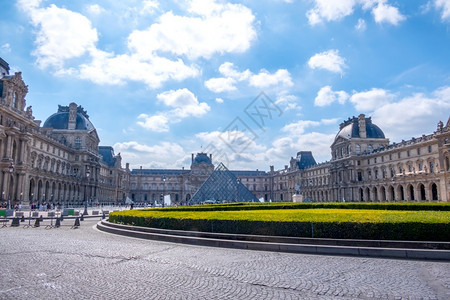 法国巴黎卢浮宫院子里的法国夏日大型花棚有剪成灌木丛卢浮博物馆庭院和绿布什大花棚建造艺术天空图片