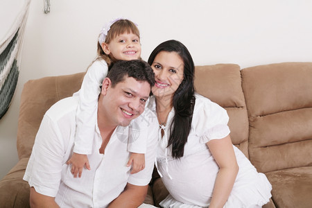 男拥抱一个幸福家庭中有孩子和孕妇以及卡斯蒂略积极图片