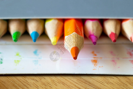 绿色纸盒灰中的彩色铅笔虹橙铅笔突出宏观学校或办公用品背景纸盒灰色中的彩铅笔学校或办公用品排创造力图片