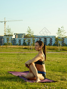户外草坪拉伸做瑜伽的青年女子图片