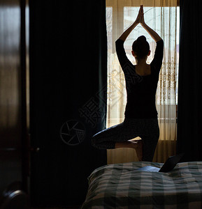 冥想打坐妇女在卧室内做瑜伽姿势在家保持身体健康精神合身图片