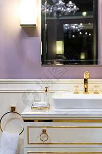 龙头美丽明亮的洗手间配有黄金白色和紫装饰品时髦的白色背景图片