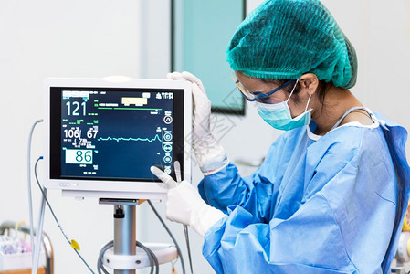 关心紧急情况面具健康护理和医疗概念院与人的主题在手术室中女医生指心率监测器妇科医生指在手术室的心脏速率监测器图片