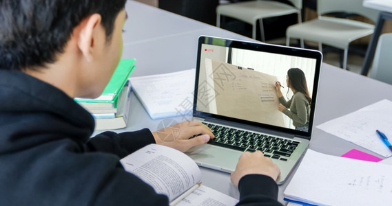 导师亚洲学生使用笔记本电脑和平板在科罗纳流行和家中隔离期间在里工作并上线求学办公室保护背景图片