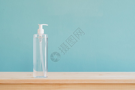 液体洗剂棕色木头桌上的酒精胶和蓝色壁纸纹身背景有复制空间清洁器图片