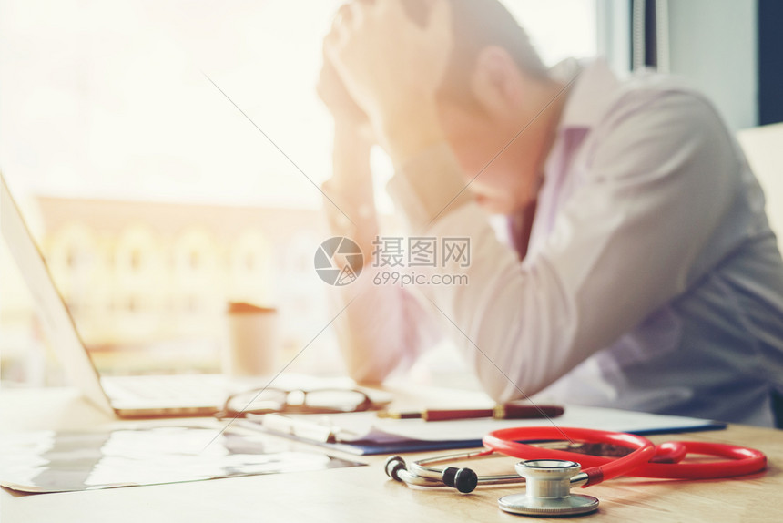 听诊镜和医生坐在笔记本电脑上头痛与在医院工作有关亚洲人诊所从业者图片