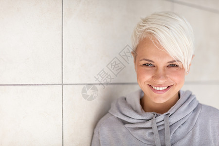 青少年欧洲的Caucasian金发女人站在墙边的照片生活图片
