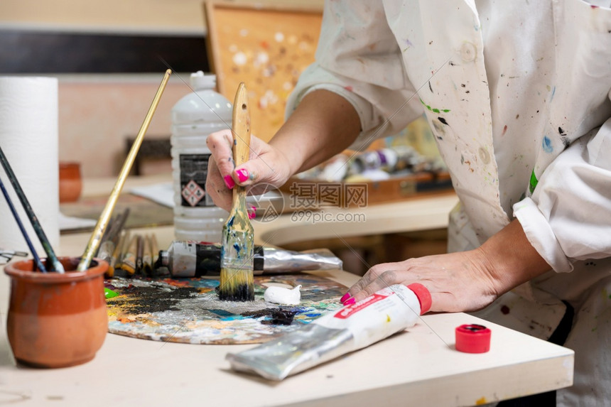 学习丰富多彩的高创意女画家在调色板近视中混合了油彩涂料的调色板切近观中混合了油彩涂料的调色板图片