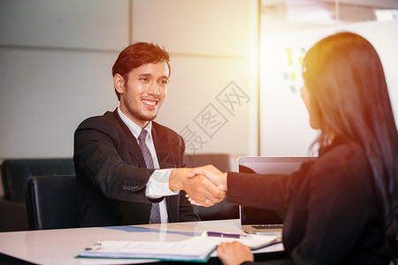 商界人士握手并微笑同意签署合并结束会议笔记本电脑沟通人们图片