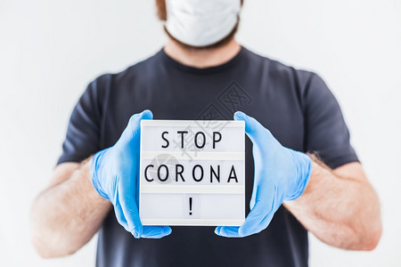 家大流行卫生保健停止使用Coronna概念的发短信灯箱在科罗纳COVID19流行病期间将Corona交给佩戴乳胶医疗手套和保护面图片