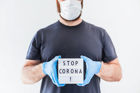 封锁安全的停止使用Coronna概念的发短信灯箱在科罗纳COVID19流行病期间将Corona交给佩戴乳胶医疗手套和保护面具的人图片