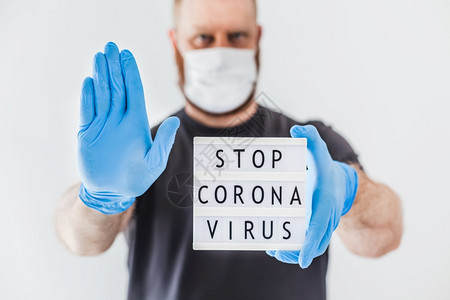 紧急情况停止使用Coronna概念的发短信灯箱在科罗纳COVID19流行病期间将Corona交给佩戴乳胶医疗手套和保护面具的人图片