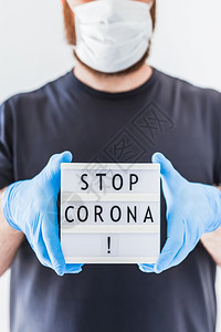 停留止使用Coronna概念的发短信灯箱在科罗纳COVID19流行病期间将Corona交给佩戴乳胶医疗手套和保护面具的人2019图片