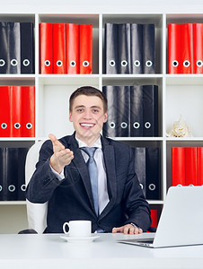 照片行政人员幸福年轻商在办公室里拿着笔记本电脑的快乐青年商人图片
