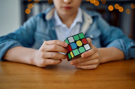 社论为了人们试图解谜立方体的小男孩有选择地关注手的玩具用于大脑和逻辑心智培训创造游戏解决复杂问题男孩试图解谜立方体专心于手图片