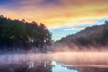 清晨多雾的湖边露营地图片
