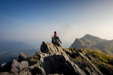 女游客坐在岩石的最顶端在日落时景色优美的DoiPhaTang旅游点Sunset景点清Rairsqopos隐藏天堂泰国DoiTan图片