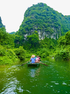 石窟景观船丛林静地在和平坦姆科克河上游行越南宁平NinhBinh背景