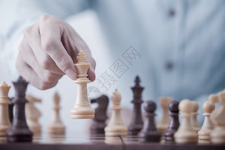 风险商人在竞争成功游戏概念战略和成功管理或领导方面玩象棋游戏并成功管理或领导才能赢挑战图片