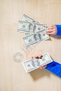钱盒人类顶视图手数钱的特写快乐孩子用美元小商人一堆美元百钞票在男孩手中美元纸币年轻的图片