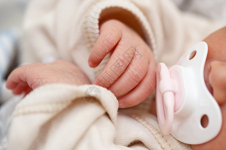 小手指新生婴儿的手紧婴儿在她嘴口里有奶油器女孩目的睡觉图片