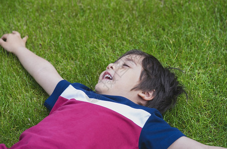 孩子们铺设坐在绿草地上笑小孩在阳光明媚的夏日玩户外游戏很愉快校对PortnoyFreakingProppedshot场地图片