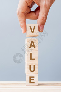 目标管理商业男子手握木立方块在表背景任务愿和核心价值概念上用价值的商业词投资图片