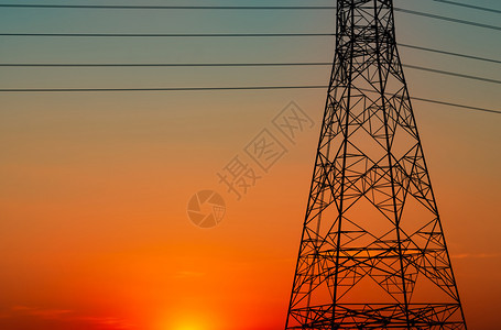 网格橙色天空的剪影高压电塔和线日落时的杆力和能源概念配电站带缆的高压网塔极强大的图片