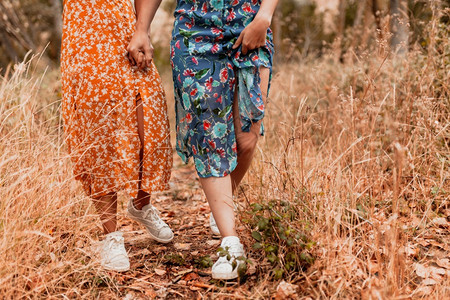 女孩两个年轻者穿着长裙在树林里走落下成人图片