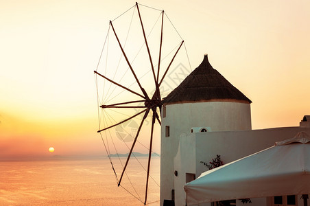 希腊圣托里尼岛上空日落奥亚村传统教堂公寓及风车日落时景全图象像海地标采取图片