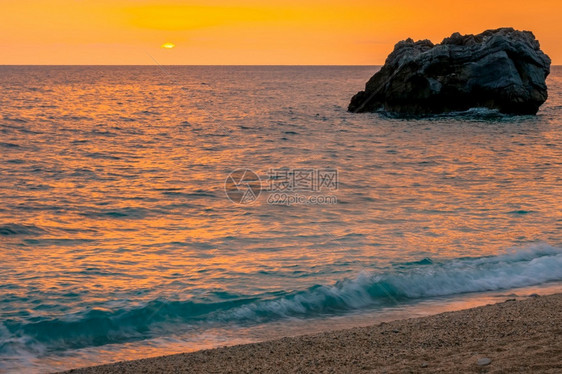 海岸金的多彩黎明和桑迪滩的开阔风平浪静水多彩日出海黎明和桑迪滩平静的图片
