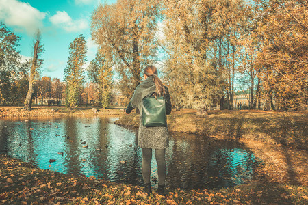 秋天湖边秋季湖边公园散步的女人背影背景