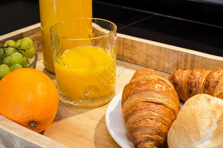 带橙汁牛角面包和水果的早餐盘酱喝房间图片