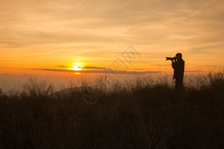 拍摄日落时风景照片的摄影记者周光片橙户外高的图片