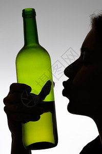 年轻的酗酒者一个女人接吻葡萄酒瓶子的休眠白种人图片