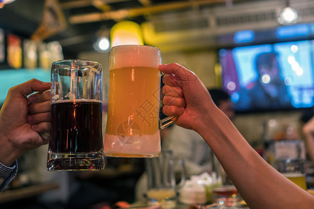两杯啤酒在吧朋友之间一起欢呼餐厅休息和喝酒的概念笑声气泡曼谷手图片